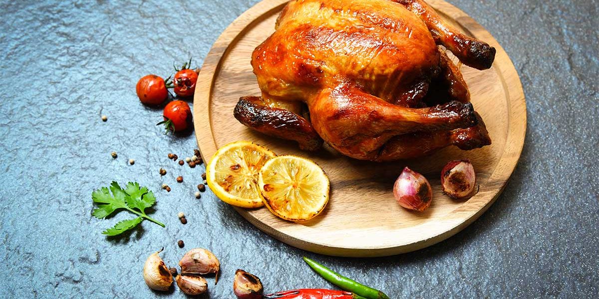 roasted-chicken-baked-whole-chicken-grilled-with-herbs-spices-wooden-plate-dark